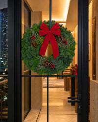 Christmas Celebration Wreath displayed on a glass entrance door