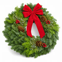 Christmas Celebration Wreath angled view with red bow, pinecones and winter berries