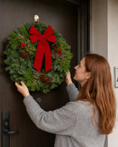 Christmas Celebration Wreath being placed on a front door